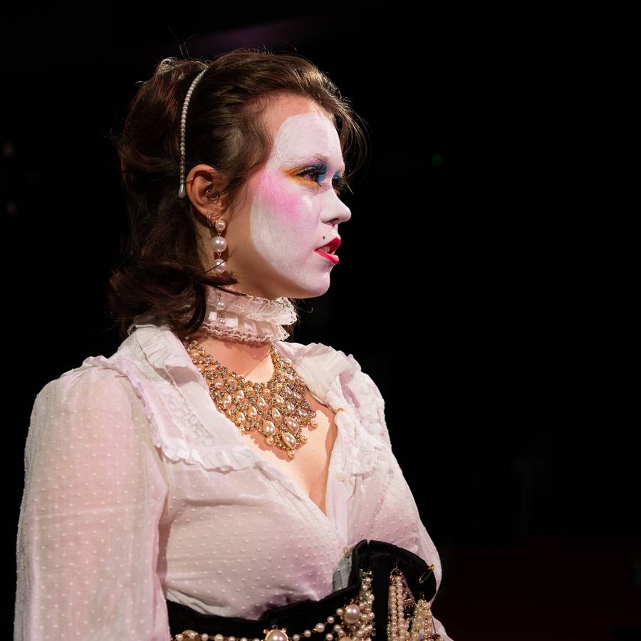Orlando performer in a white costume and pearl jewellery